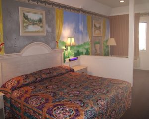 King bed, night stand, bedside light, mural art, carpet flooring