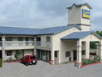 hotel entrance with drive through canopy, two story building with exterior room entrances, parking spaces