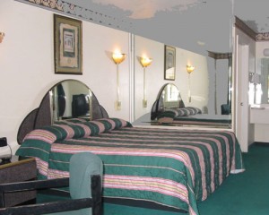 king bed, mirrored headboard and wall, night stand, chair, carpet flooring