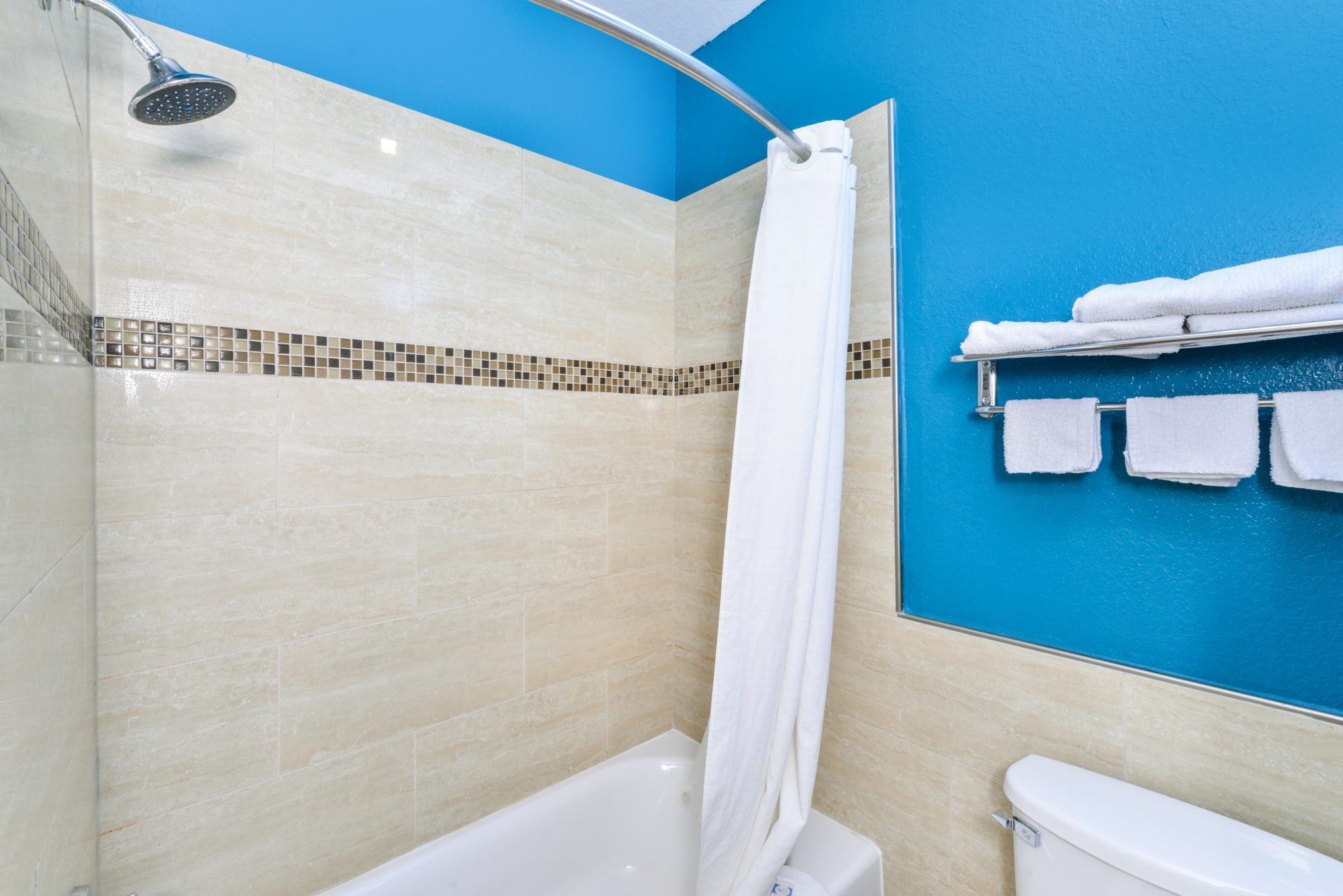 Shower tub with shower curtain, twoel rail and shelf with towels, toilet