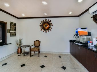 Breakfast display with juice dispensers, chair, occasional talbe, dried flowers in vase, guest check in desk