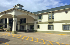 Canopied hotel entrance, vending machine, two story building with exterior room entrances with covered walkways and stairs