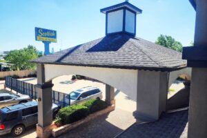 Hotel drive through canopied entrance, brand signage, parking spaces
