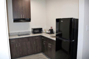 Fridge, base and wall cabinets with hob, cooker hood, microwavem coffee maker, tiled flooring