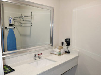 Vanity unit, mirror, ice bucket, hair dryer, wall mounted ironing board and iron