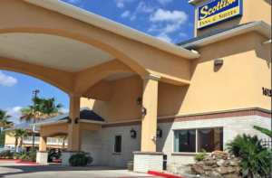 Hotel entrance with canopied drive through, landscaping with trees