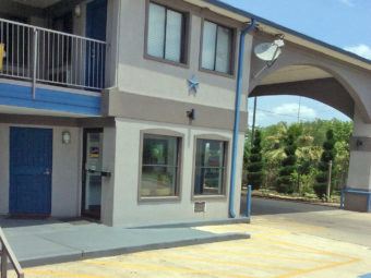 Hotel entrance with canopied drive through, two story building with exterior room entrances and covered walkways