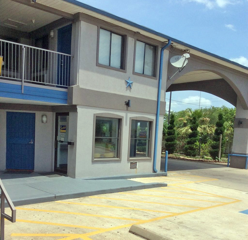 Hotel entrance with canopied drive through, two story building with exterior room entrances and covered walkways