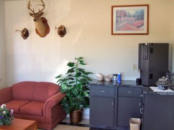 Sofa, deer heads on wall and art, coffee machine , coffee table, tiled flooring