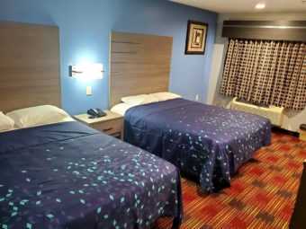 Two queen beds, night stand with telephone, wall bedisde lights,art image, carpet flooring