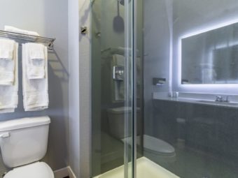 toilet, towel rail and shelf with towels, shower with glass doors