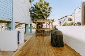 Gazebo with bench seat and bar with bar stools, grill, wooden flooring