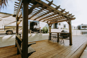 Gazebo with bench seat and bar with bar stools, grill, wooden flooring