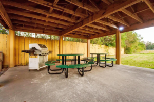 Guest covered BBQ area with grill, tables and seating, and grassy areas