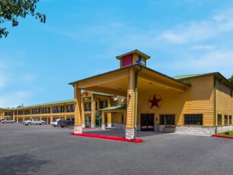 Hotel canopied drive trhough entrance, two story building with covered walkways and exterior guest room entrances, parking spaces