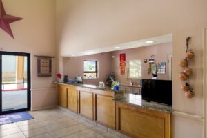 Guest check in desk, doors leading to parking area, tiled flooring