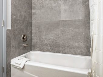 Shower tub with shower curtain, bath mat and bath amenities