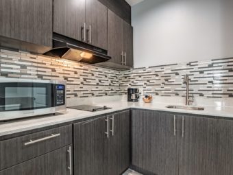 Wall and base cabinets with cooker hood, counter top with microwave, hob,coffee maker, sink