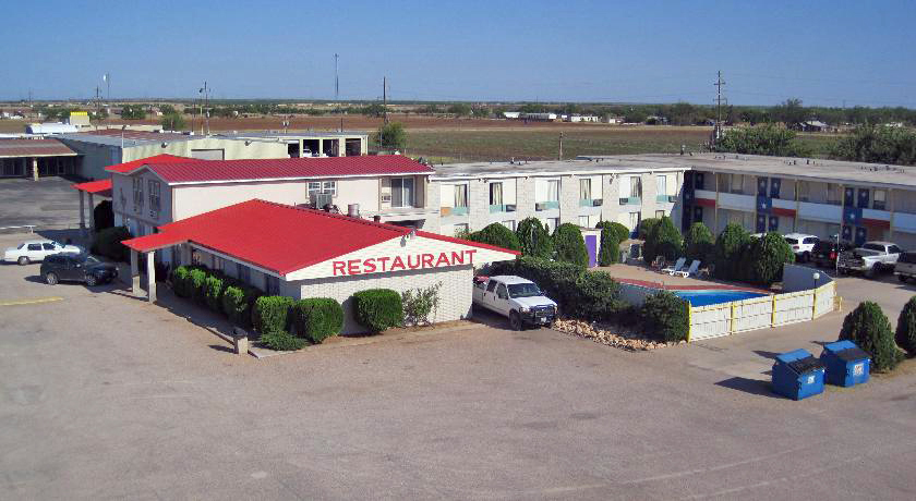 STXME Exterior 6 Two story building, restaurant, small bushes, exterior pool behind fence,parking spaces