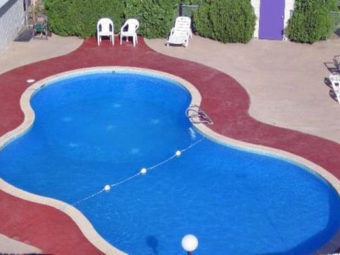 Exterior pool, concrete poolside with patio chairs and loungers