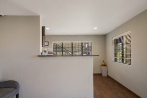 Guest check in desk, easy chair, planter with flowers, tiled flooring