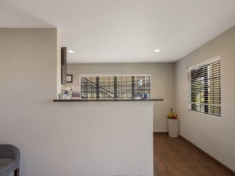 Guest check in desk, easy chair, planter with flowers, tiled flooring