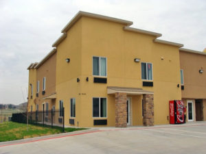 Hotel entrance, two story building, soda vending machine, parking spaces