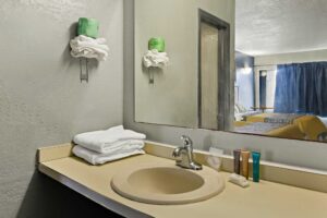 Vanity unit with towels and bathroom amenties, mirror