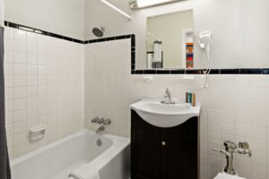 Shower tub with shower curtain and bath mat, vanity unit, hairdryer, mirror