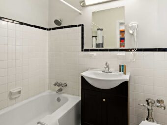 Shower tub with shower curtain and bath mat, vanity unit, hairdryer, mirror