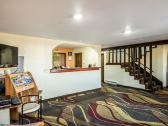 Guest check in desk, guest information leaflet stand, flat screen TV, stairs to next floor, carpet flooring